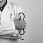 doctor crossing arms while holding stethoscope white coat