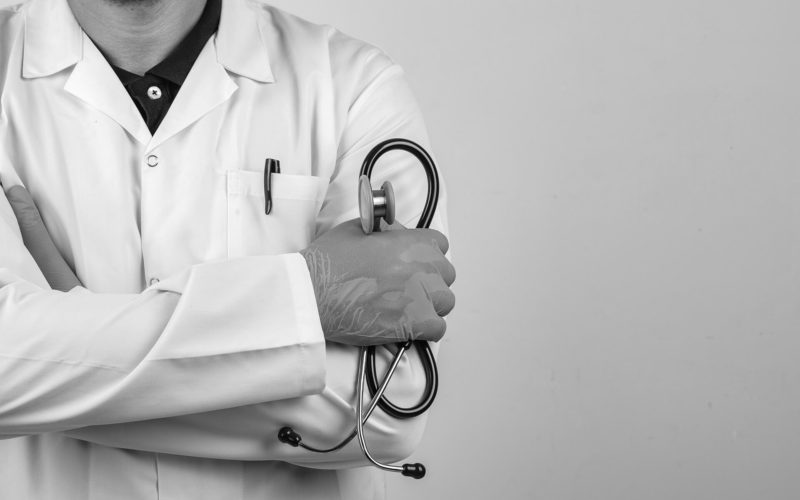 doctor crossing arms while holding stethoscope white coat